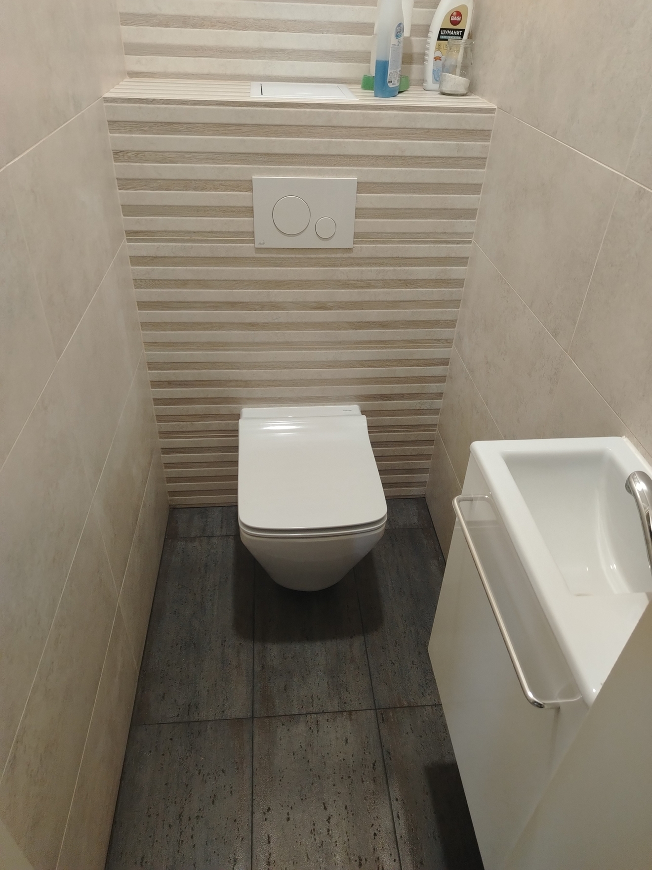 В санузле выполнена укладка керамогранита с установкой и подключением инсталляции и умывальника.
Процесс: Поверхность подготовлена, плитка уложена, проведена установка сантехники с подключением коммуникаций.