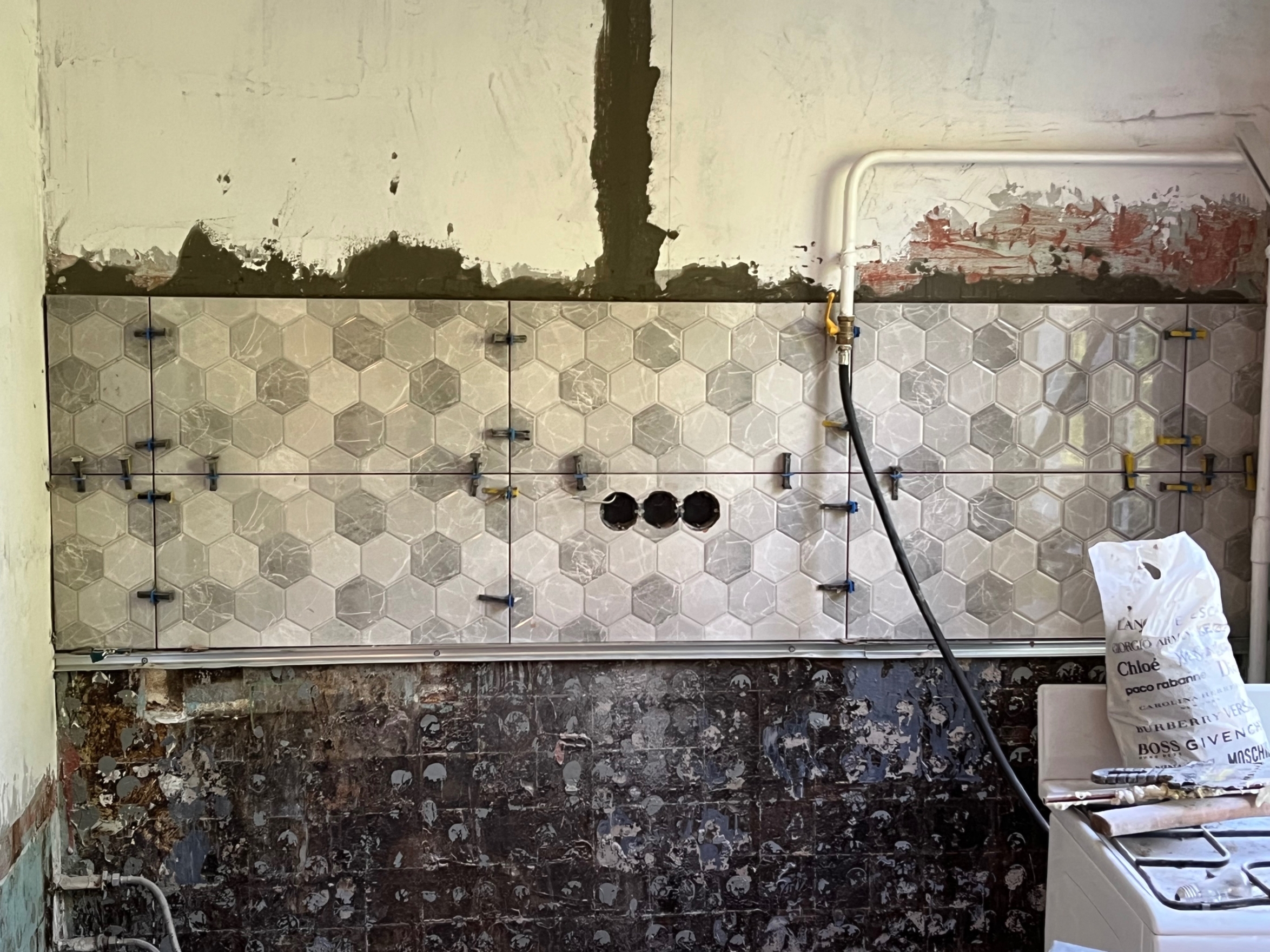 Аккуратно выполнена штроба для скрытой укладки проводки, розетки выведены на оптимальной высоте для кухонной техники.
Фартук уложен ровно, с идеальной стыковкой швов, а розетки готовы к подключению.