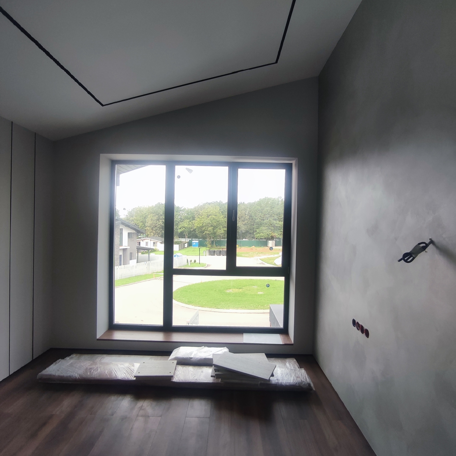  Декоративная штукатурка на стенах, матовая краска для потолка, деревянный пол с лаком, алюминиевые оконные профили.
Стены выровнены, нанесена штукатурка, потолок окрашен в нейтральный оттенок, установлены панорамные окна для естественного освещения.