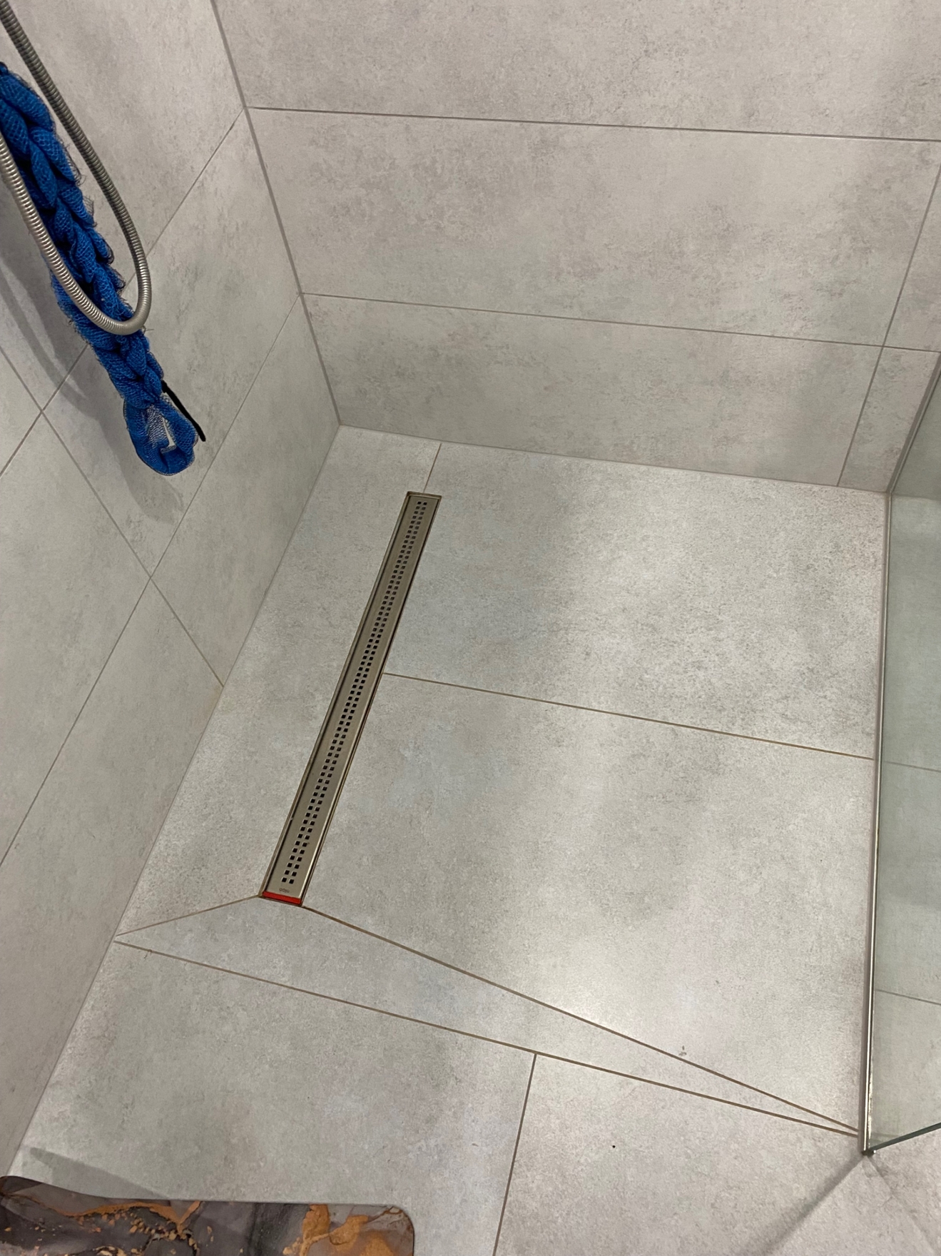 Этот душевой трап установлен вровень с полом. Сантехническая подводка труб выполнена скрыто, с соблюдением уклонов для эффективного слива. Работы проведены под ключ: от монтажа трапа и труб до финальной отделки пола.