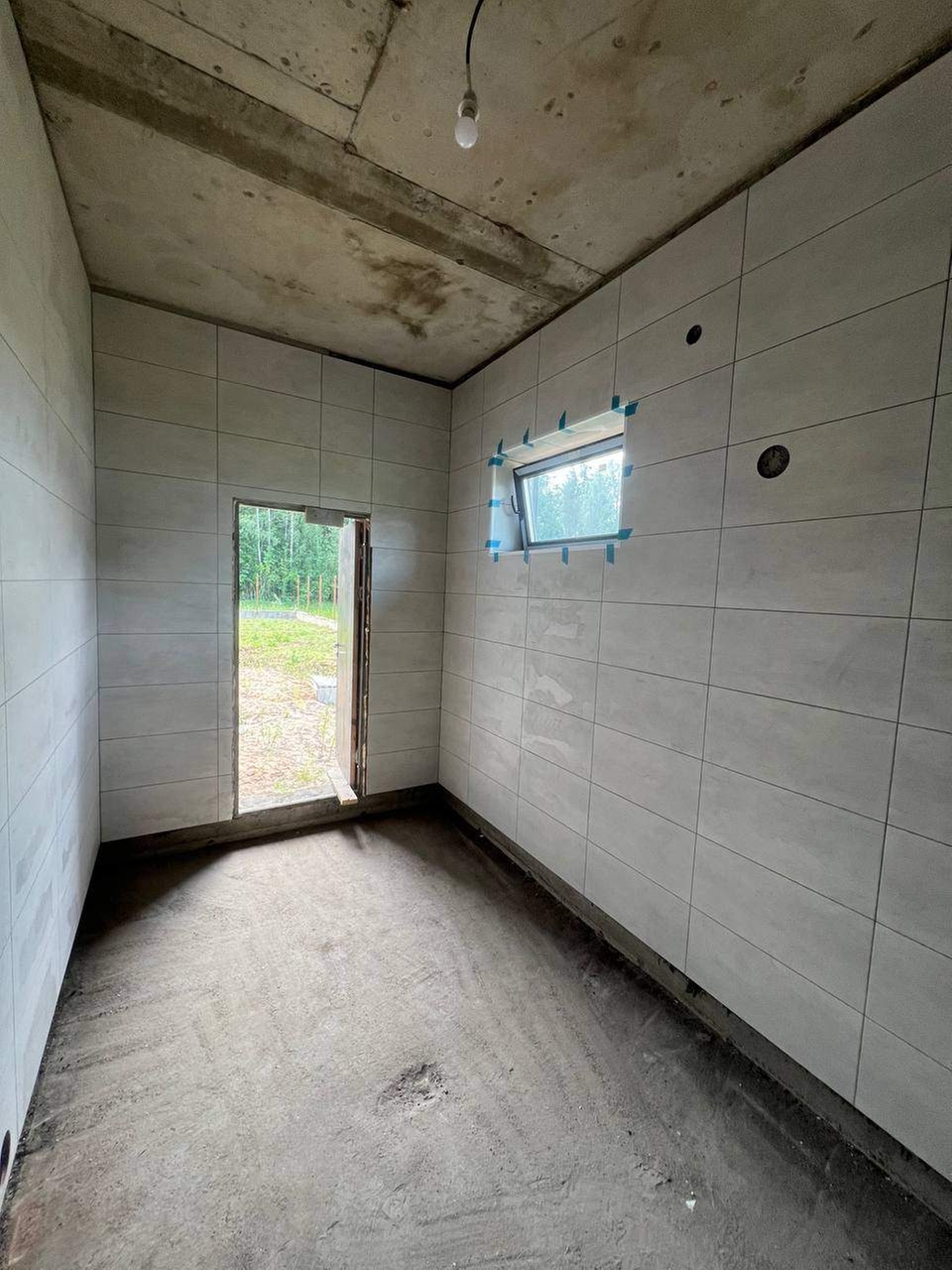 Облицовка стен плиткой в котельной с изготовлением откосов для дверных проёмов.
Поверхность стен подготовлена и обработана грунтовкой, выполнена укладка плитки на клей, изготовлены и облицованы откосы, швы затерты.