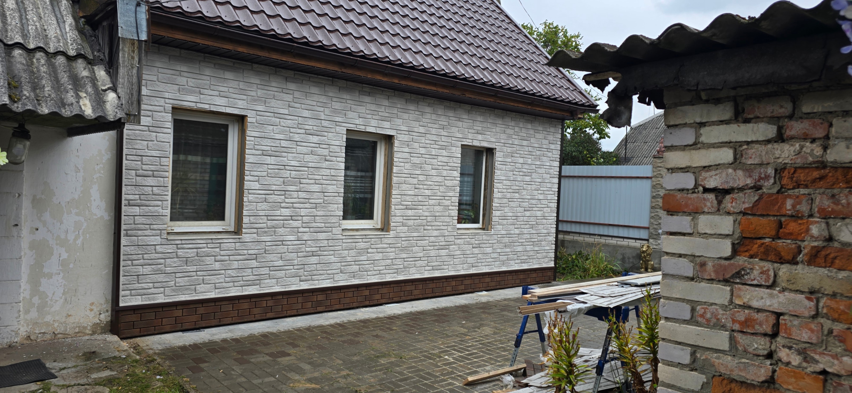 Обшивка дома и цоколя сайдингом, имитирующим каменную кладку. Установлены качественные примыкания для защиты от влаги и ветра, обеспечивающие герметичность и надёжность конструкции.