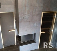 В сауне выполнена укладка крупноформатной плитки, также облицевал ею портал камина. Для этого проекта специально подготовил идеально ровное основание и использовал термостойкий клей. Все швы заполнены контрастной затиркой для подчеркивания геометрии.