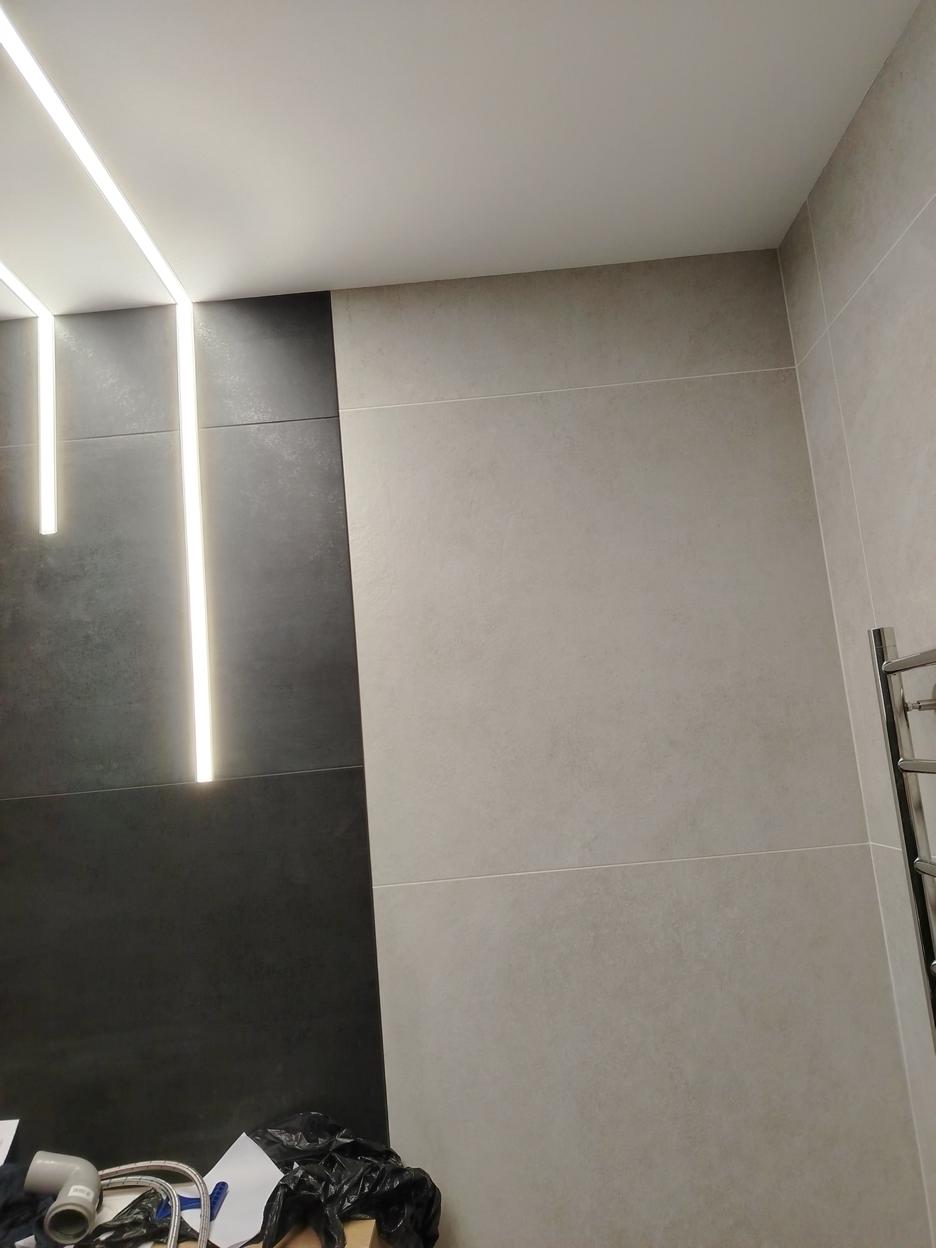 Произведена укладка керамогранита формата 1200 на 600 мм в санузле с предварительной подготовкой и выравниванием поверхности стен.