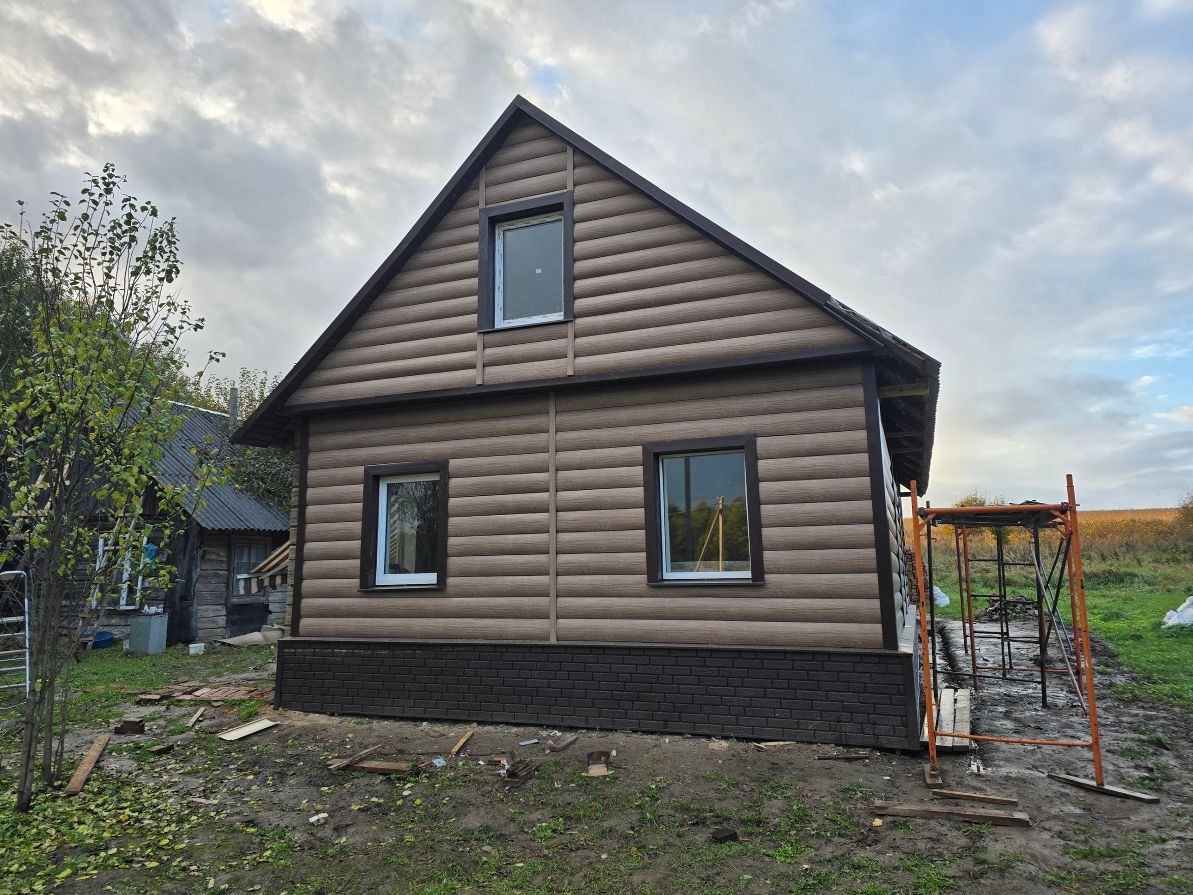 На фото представлен дом, полностью обшитый сайдингом блок-хаус, с подшивкой свесов крыши.