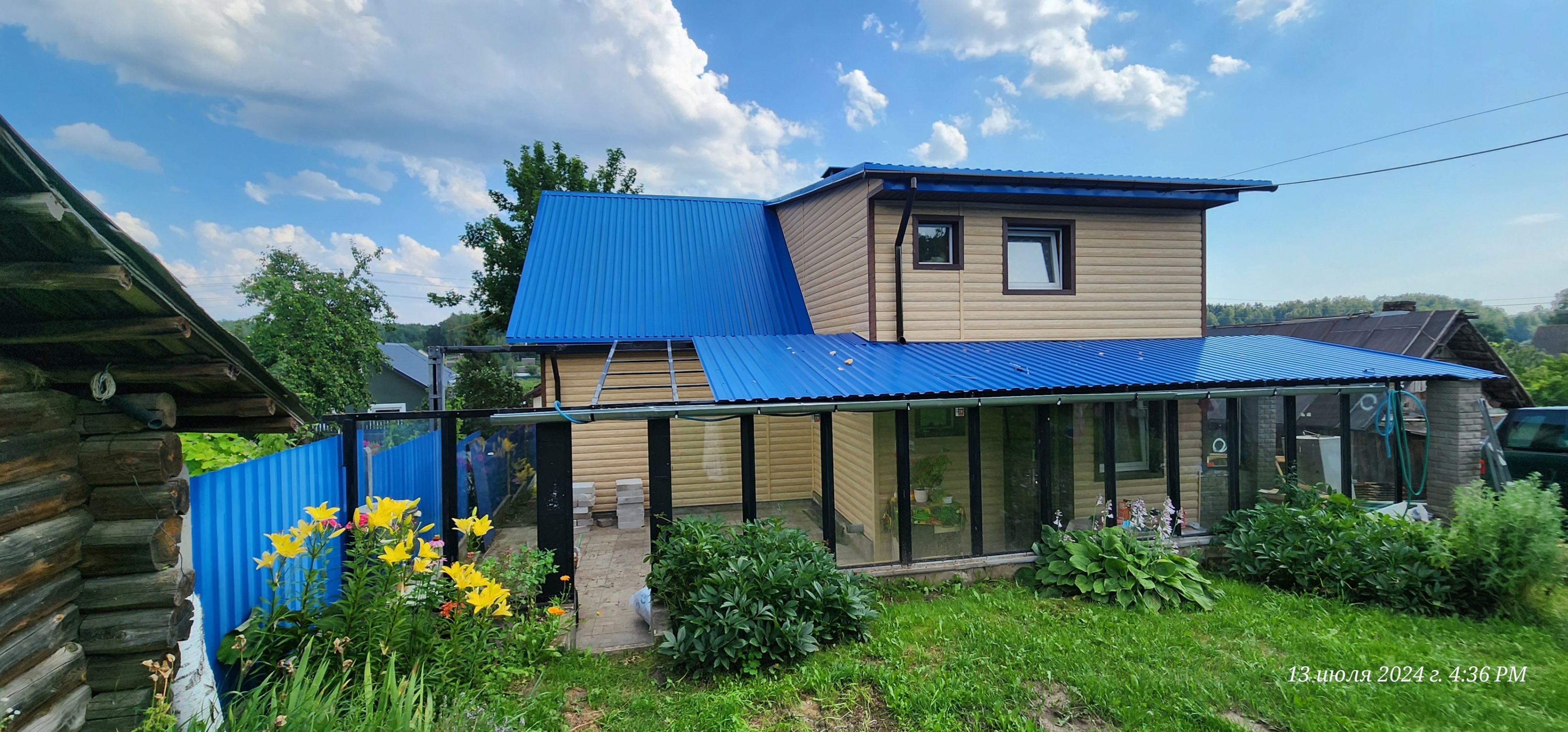 На фото — отделка фасада сайдингом с подшивкой свесов крыши софитами. Установлена водосточная система для защиты от осадков.