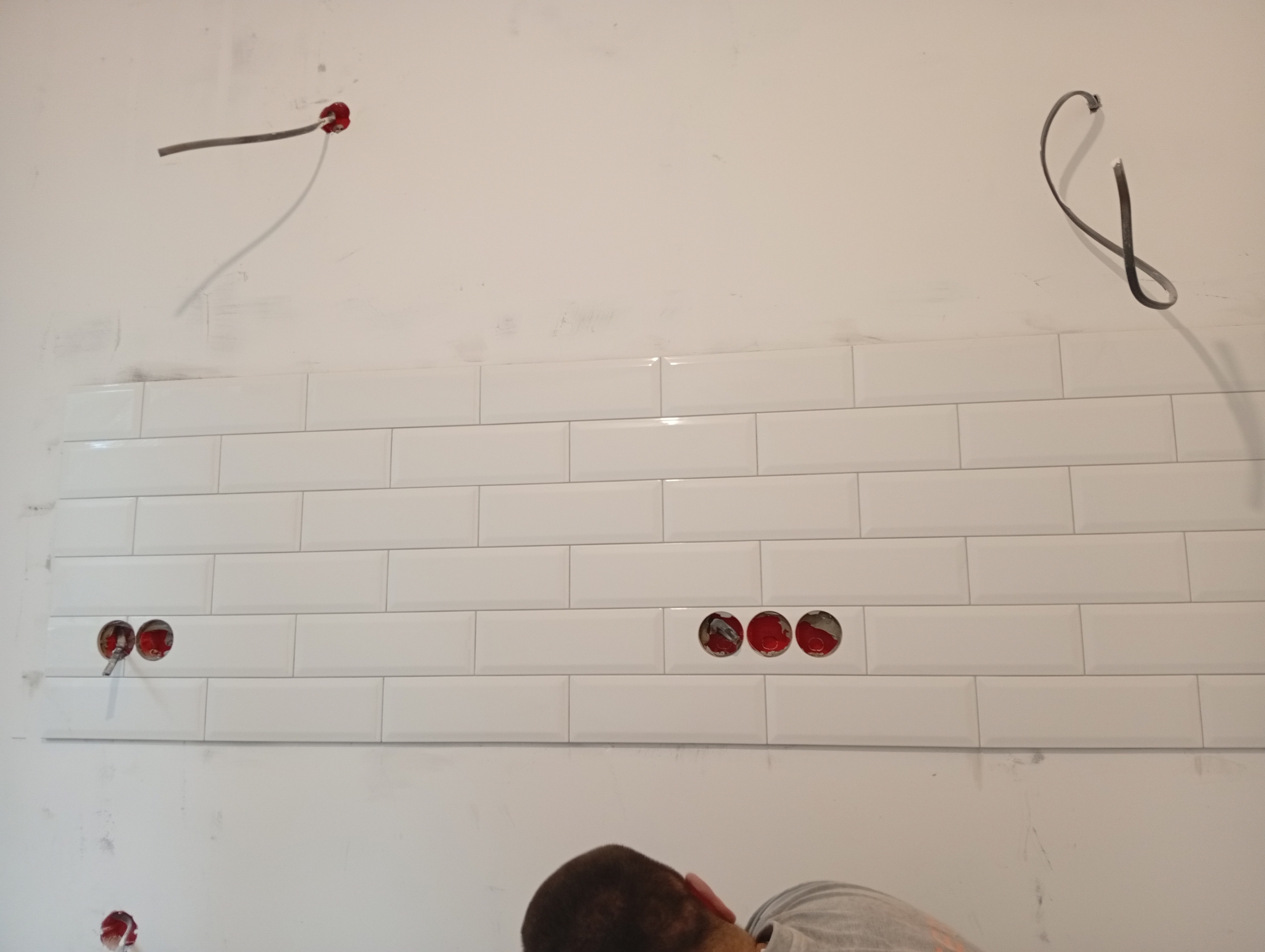 На фото кухонный фартук "кабанчик".
Плитка укладывалась на подготовленную ровную поверхность с помощью плиточного клея и крестиков для равномерных швов.
Электропроводка выводилась через специальные отверстия в плитке для подключения розеток или освещения.