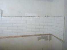 Укладка фартука на стене кухни из керамической плитки.