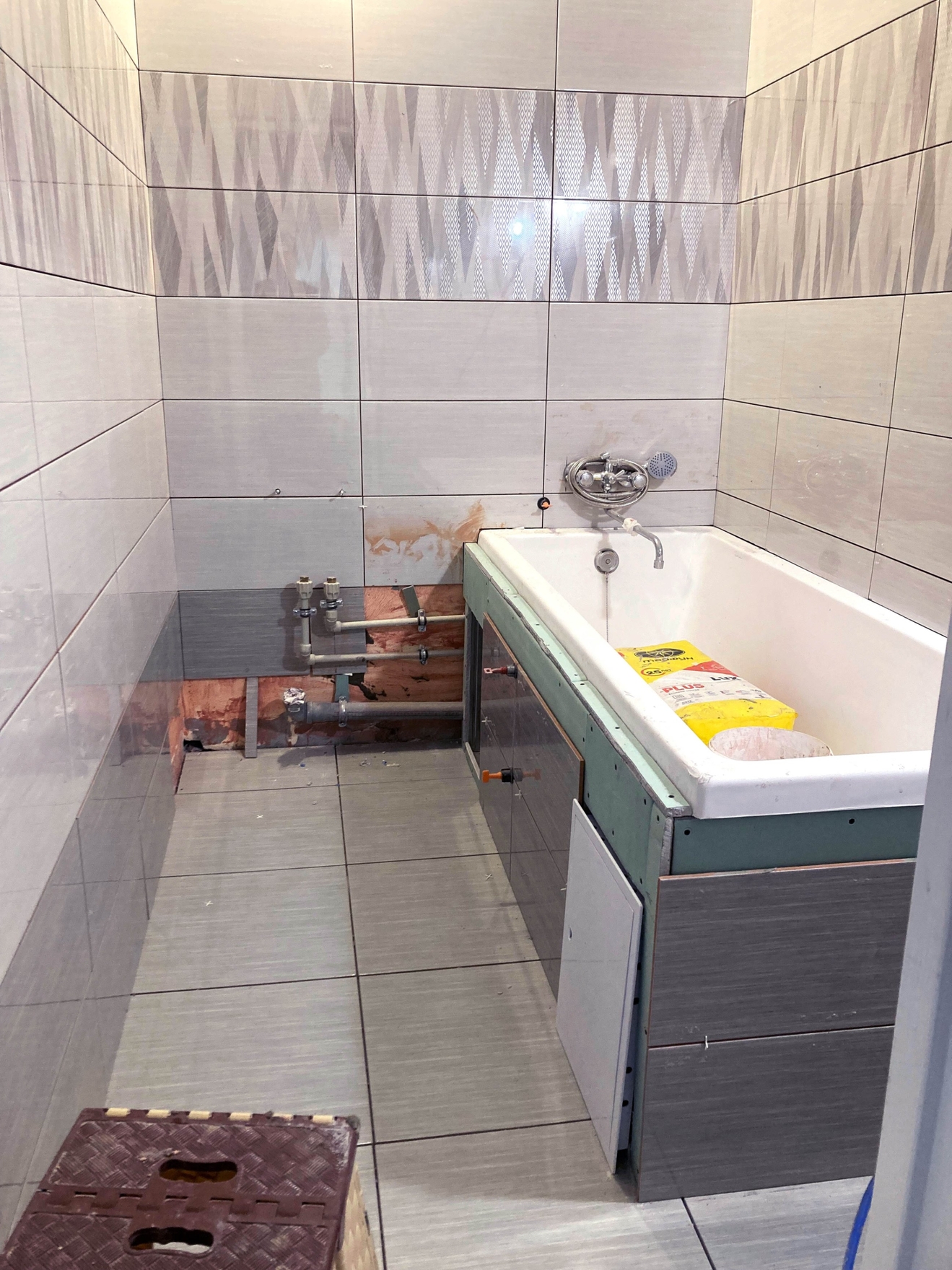 Укладка плитки на пол и стены в ванной комнате. Установка потайного люка под ванной.