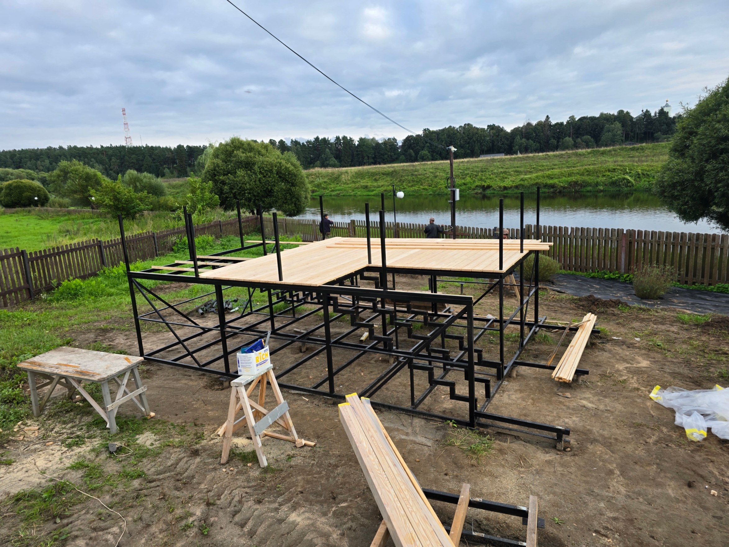 На фотографии представлен процесс строительства террасы: смонтирован металлический каркас, который служит основой для будущей конструкции. Для обшивки будет использоваться террасная доска, укладываемая на подготовленную основу.