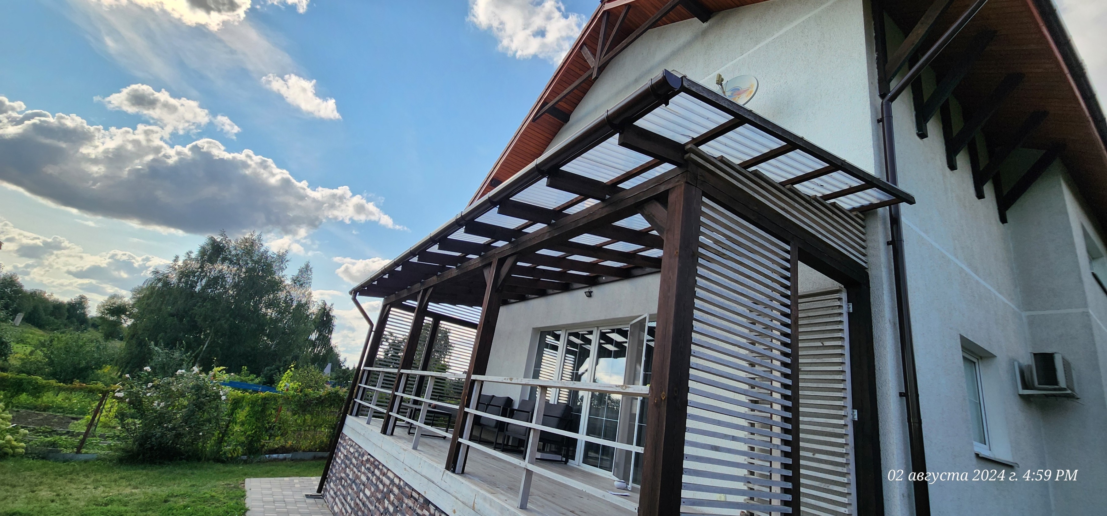 Смонтирована терраса под ключ на металлическом каркасе с настилом из древесно-полимерного композита. Работы включали установку опор, монтаж односкатной кровли из профлиста и отделку перил.