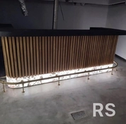 Изготовил ресепшен с комбинированной конструкцией. Столешница выполнена из каменного шпона, основание собрано из имитации рейки баффель со встроенной LED-лентой. Произвел сварочные работы для каркаса и создал изогнутые элементы под световое панно.