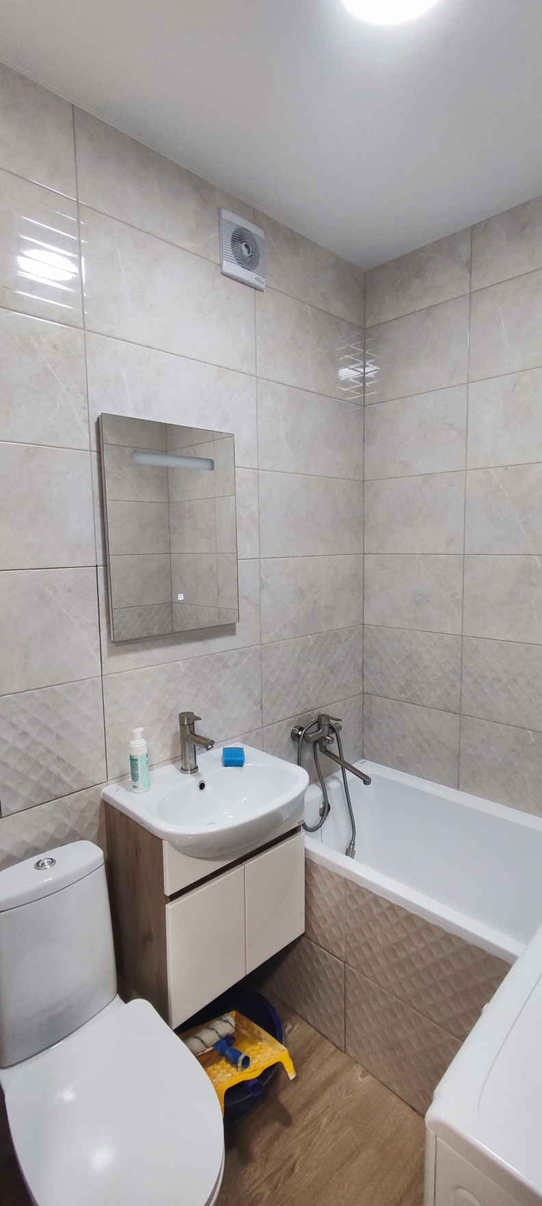 Использована плитка светлых оттенков, современная сантехника и аксессуары, зеркало с подсветкой.
Укладка плитки на выровненные стены, монтаж сантехники, установка зеркала и герметизация швов влагостойким составом.