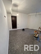 Осуществлена укладка плитки формата 120×60 см в помещении. Стены зашпаклеваны для создания ровной поверхности. Швы обработаны эпоксидной фугой, установлен плинтус из дюрополимера для завершённого вида.