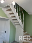 На фото представлено заделывание стыков примыкания деревянной лестницы к стене с последующей покраской в два слоя.