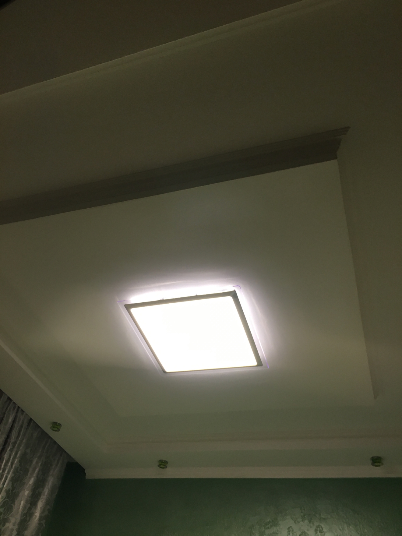 На этом фото показан подвесной потолок из гипсокартона с установленным встраиваемым светодиодным светильником квадратной формы.