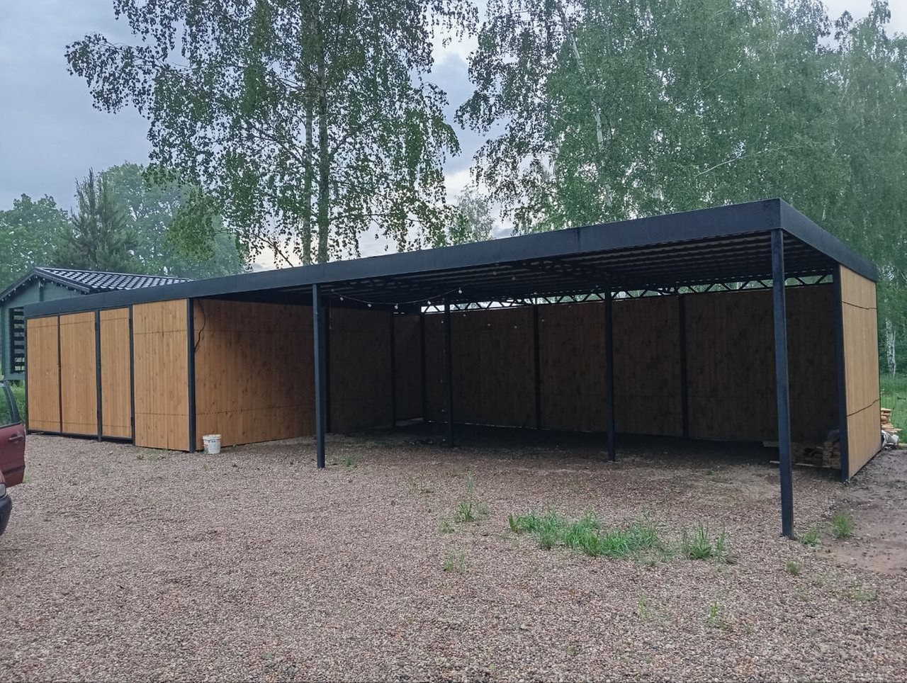 Автомобильный навес включает в себя два хозяйственных блока размером 3×6 м, санузел 2×2 м и рассчитан на размещение трёх автомобилей. Габариты навеса: 15×6×3 м.