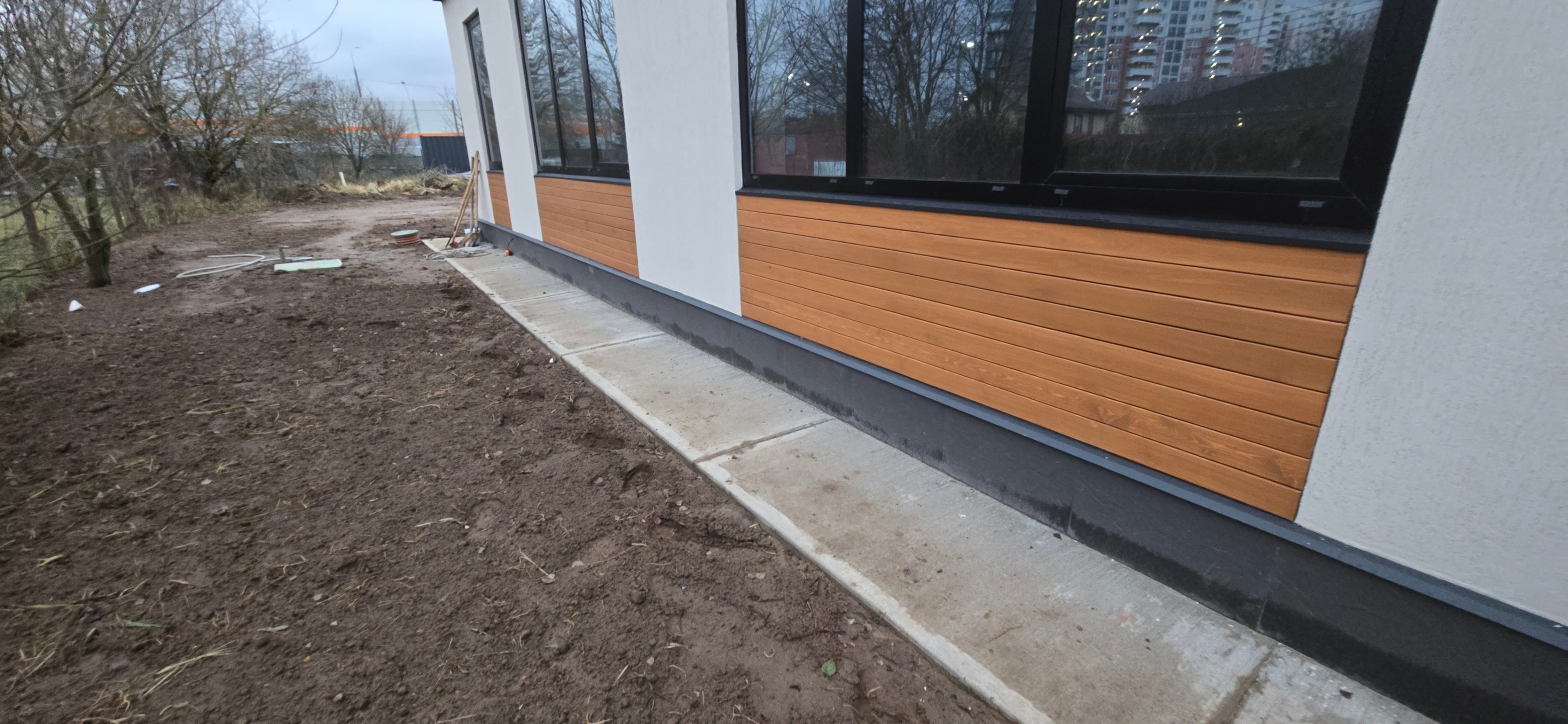 Обшивка фасада планкеном. Установлены металлические отливы, защищающие стены от влаги и продлевающие срок службы отделки. Работа включает финальную покраску для дополнительной защиты. Все этапы выполнены под ключ.