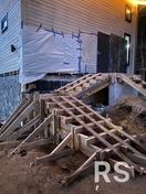 На фото показан процесс установки опалубки под лестницу. Конструкция собрана из влагостойкой фанеры и армирована перед заливкой бетона.