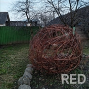 Фото декоративного шара: плетёная ивовая сфера установлена на участке.