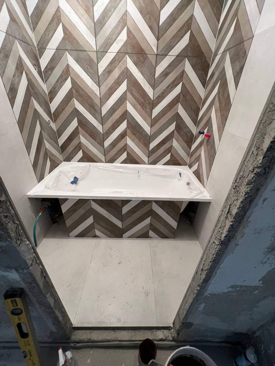 Облицовка стен керамогранитом размером 1200×600 мм в ванной комнате с изготовлением и установкой экрана под ванну.