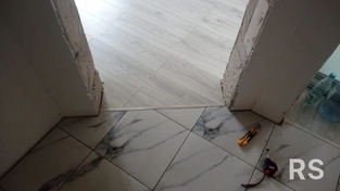 На фото показан завершённый монтаж ламината в дверном проёме с аккуратным стыком и металлическим порожком.
Для установки использовались точные замеры, подрезка ламината и надёжное крепление порога к основанию.