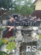 Композиция искусно вписана в ландшафт альпийской горки, имитируя средневековые руины. Каждый элемент выкован вручную и состарен, чтобы придать сооружению естественный вид древней каменной кладки.