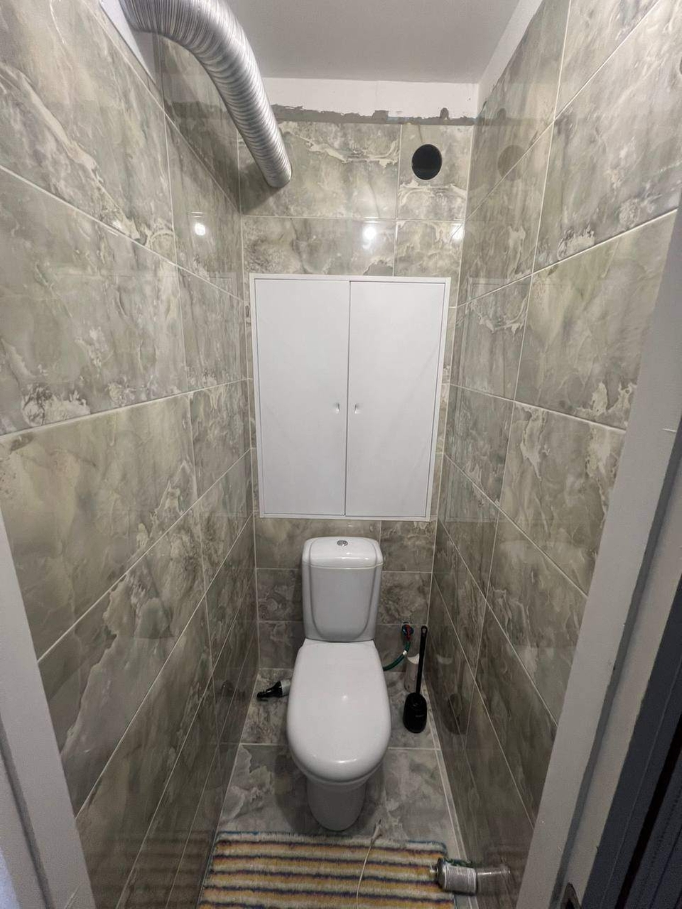 Проведена укладка плитки на стены санузла с использованием плитки размером 900 × 300 мм.