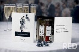 Дизайн открытки для мобильного приложения выполнен в современном минималистичном стиле с использованием контрастных чёрно-белых оттенков. Композиция сочетает графические элементы и фотографию, создавая визуальный акцент на продукте.