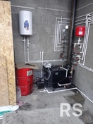 На фото показан монтаж котельной в частном доме: установлены газовый котёл, расширительный бак, группа безопасности и коллекторная разводка труб.