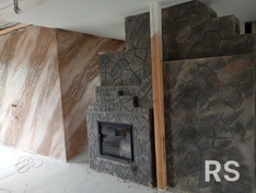 На камин нанесено декоративное покрытие с имитацией травертина трёх оттенков, защищённое лаком. Отделка выполнена под натуральный камень для создания естественного вида.