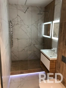 На фото — санузел под ключ: монтаж сантехники, укладка плитки, установка встроенной душевой системы и стеклянных перегородок.