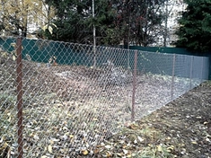 Установленный забор из оцинкованной сетки рабицы